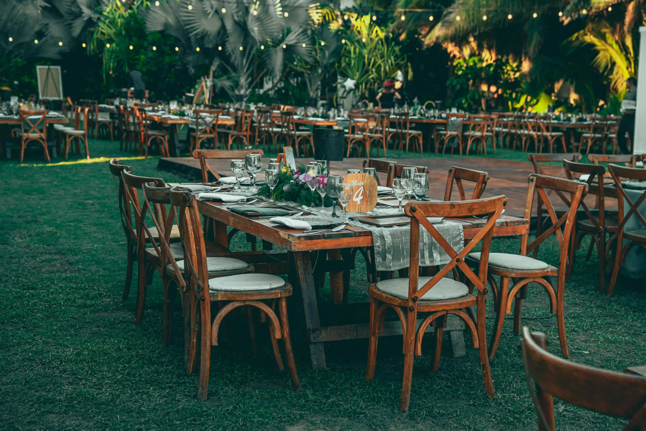 Espacio exterior para evento corporativo con mesas y zona de jardín